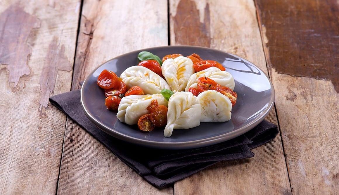 Norwegischer Stockfisch und Kartoffel-Culurgiones mit Baby-Eiertomaten-Confit und Basilikum