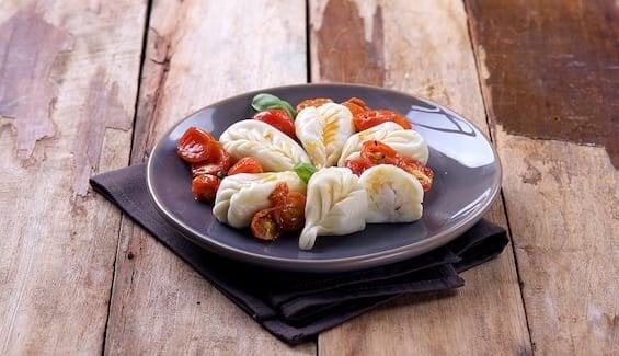 Norwegischer Stockfisch und Kartoffel-Culurgiones mit Baby-Eiertomaten-Confit und Basilikum